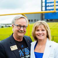 Guests posing on the field at the Jamie Hosford Football Center dedication.